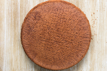 Chocolate sponge cake on wooden background. Top view