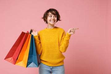 Smiling young brunette woman girl in yellow sweater posing isolated on pink background. People...