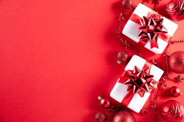 Christmas background concept. Top view of Christmas gift box red and golden ball with snowflakes on light red pastel background.