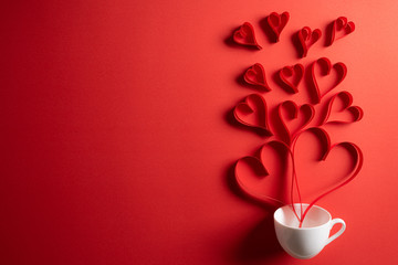 Red paper hearts splash out from white coffee cup on red paper background. Love and Valentine's day concept. - obrazy, fototapety, plakaty