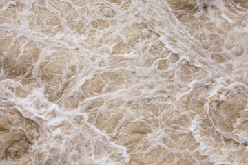 Abstract background, rough pink water surface. Foaming pink water. Foam and bubbles. Salmon, epic sea. Splendor, magnificence and power of nature concept. Foam pattern.