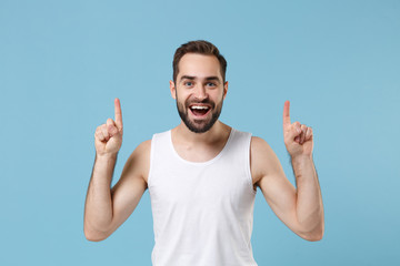 Naklejka premium Happy bearded young man 20s years old perfect skin wearing white shirt isolated on blue pastel wall background, studio portrait. Skin care healthcare cosmetic procedures concept. Mock up copy space.