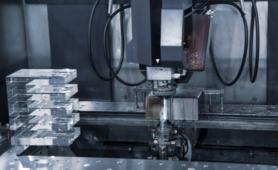 Electrical discharge machine EDM cutting workpiece in workshop. Industrial metalworking machinery