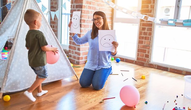 Young therapist woman speaking with child, counselor and behaviour correction at the office around toys