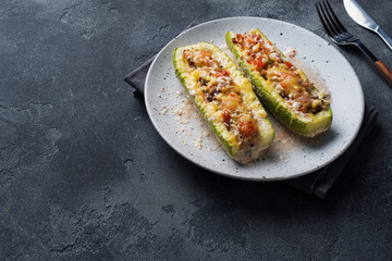 Baked stuffed zucchini boats with minced chicken mushrooms and vegetables with cheese on a plate. Copy space