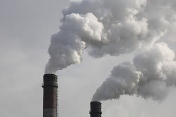Factory chimneys smoking with dense white smoke. Industrial pollution of air, electric plant...