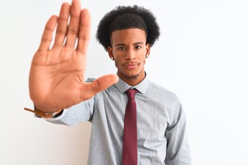 Young african american businessman wearing tie standing over isolated white background doing stop sing with palm of the hand. Warning expression with negative and serious gesture on the face.