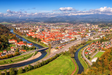 Fototapeta na wymiar City of Celje in Slovenia, Styria, panoramic aerial view from old castle ancient walls. Amazing landscape with town in Lasko valley, river Savinja and blue sky with clouds, outdoor travel background