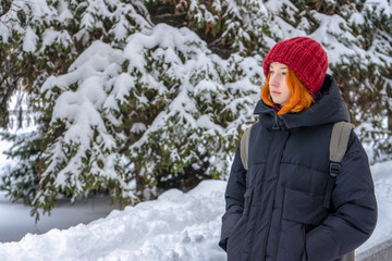 Fototapeta na wymiar Teen girl wearing casual clothes walking on snow covered city street in winter. Young lady spending weekend in city. Urban vacation, winter holiday, slow life. Fashionable outfit, youth fashion