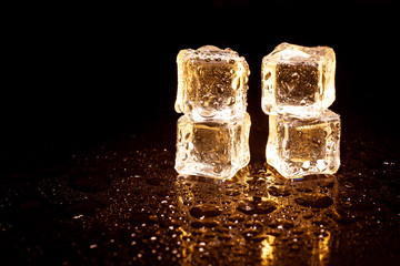 Golden ice cubes on black background.