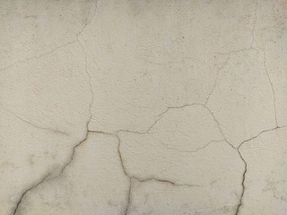 Obraz premium Old and dirty rough textured wall going yellow with visible black cracks and signs of decay and destruction for cool wallpaper background