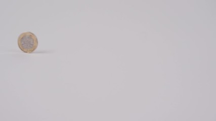 Slow motion pound and euro coins rolling past each other without touching  - Powered by Adobe