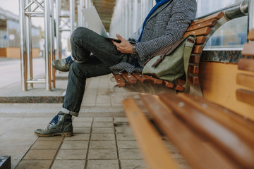 Elegant gentleman working on laptop on the street