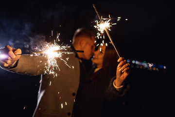 Fototapeta premium Romantic couple in love celebrate together the new year start or event party nightlife with fire sparkler