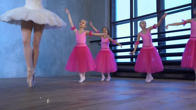 Little girls dance ballet. Children in ballet class. Little ballerinas and teacher.