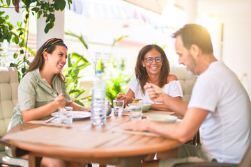 Beautiful family sitting on terrace eating foods speaking and smiling