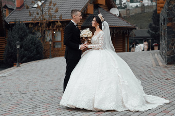 Naklejka premium Bride and groom posing. Just married loving couple in wedding dress and suit in autumn. Bride and groom having a romantic moments on their wedding day.