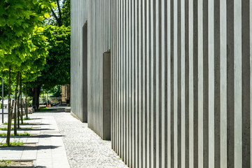 Concrete facade of modern building and sidewalk in downtown on a sunny summer day.