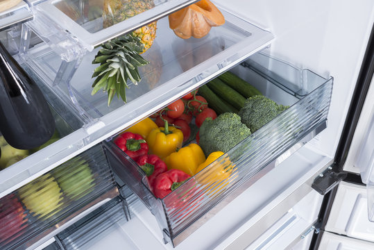 Open fridge full of fresh fruits and vegetables