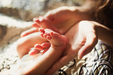 tiny fingers of the heel of the newborn in the hands of mom of daddy parent. Parenthood responsibility happiness love care obligations pediatrician birth childbirth