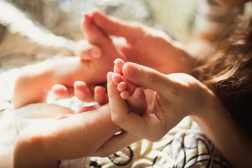 tiny fingers of the heel of the newborn in the hands of mom of daddy parent. Parenthood responsibility happiness love care obligations pediatrician birth childbirth