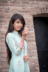 Smiling ethnic girl, hand in traditional indian mudra gesture stand. Girl in traditional Indian...
