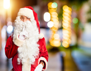 Middle age handsome man wearing Santa Claus costume and beard standing Thinking concentrated about doubt with finger on chin and looking up wondering
