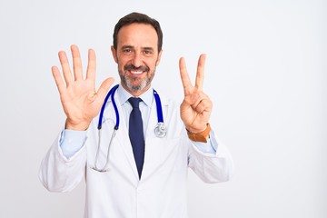 Middle age doctor man wearing coat and stethoscope standing over isolated white background showing and pointing up with fingers number seven while smiling confident and happy.