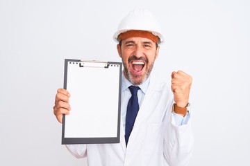 Senior engineer man wearing security helmet holding clipboard over isolated white background screaming proud and celebrating victory and success very excited, cheering emotion
