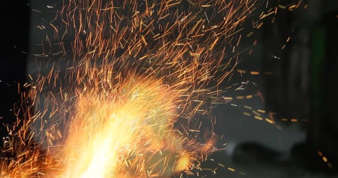 Blacksmith is using hammer to forge metal