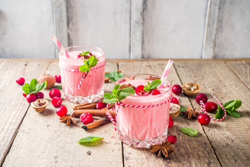 Autumn winter vitamin healthy drink. Homemade cranberry smoothie with mint and spices, wooden...