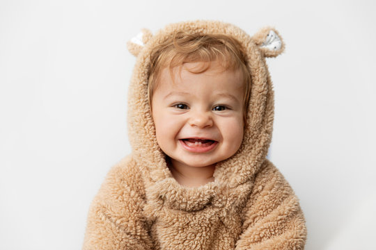 Cute laughing baby in hooded bear suit