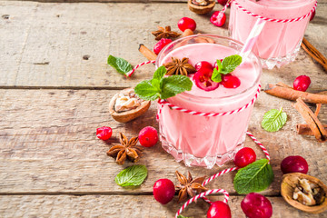 Autumn winter vitamin healthy drink. Homemade cranberry smoothie with mint and spices, wooden background