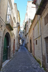 Fototapeta na wymiar Sessa Aurunca, Italy, 11/30/2019. A small street among the old houses of a medieval village in the province of Caserta