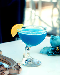 blue drink with an orange slice in the original glass
