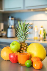 Different tropical fruits and smoothie on home kitchen background, healthy eating lifestyle concept