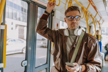 Handsome stylish man taking a tram to work - obrazy, fototapety, plakaty