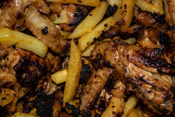 Chicken wings marinated with spices fried in a pan with potatoes. Home cooking