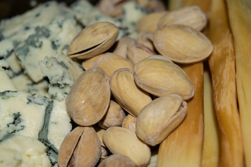 Salt-fried pistachios, Gorgonzola and smoked cheese. Close up