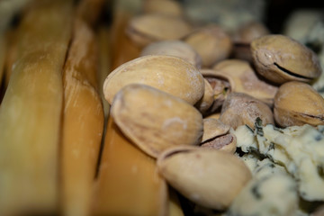 Salt-fried pistachios, Gorgonzola and smoked cheese. Close up