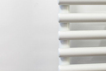 detail of a white tubular radiator on a white wall. heating in tubular steel. interior of a new home