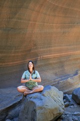 Young beauitufl hiker woman trekking natural orange mountain doing yoga pose on summer holidays