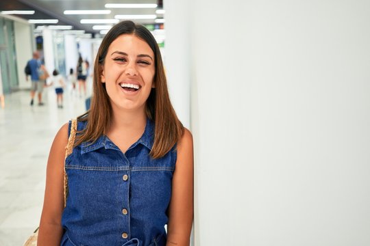 Young traveller woman at the airport going on vacation leaning on the wall