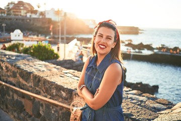 Beautiful young woman walking on beach promenade enjoying ocean view smiling happy on summer vacation