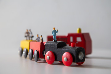 Fototapeta premium Concept: Education for children learning in school,Miniature people car works on a multicolored Wooden car on a white wooden table,&nbsp;Creative background Teamwork for global transportation