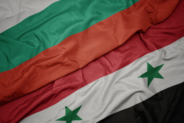 waving colorful flag of syria and national flag of bulgaria.