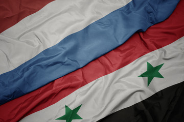 waving colorful flag of syria and national flag of luxembourg.