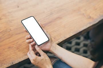 Mockup image blank white screen cell phone.men hand holding texting using mobile on desk at coffee shop.background empty space for advertise text.people contact marketing business and technology 
