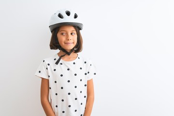 Beautiful child girl wearing security bike helmet standing over isolated white background smiling looking to the side and staring away thinking.