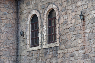 Looking at a building wall and two windows in medieval style